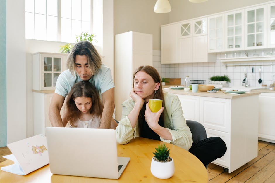 Term life insurance quotes review at the kitchen table: a young parent couple seated together with a laptop and a clipboard, the kind of household sit-down where pulling term life insurance quotes from six carriers in a single hour translates directly into hundreds of dollars of annual premium savings on identical coverage