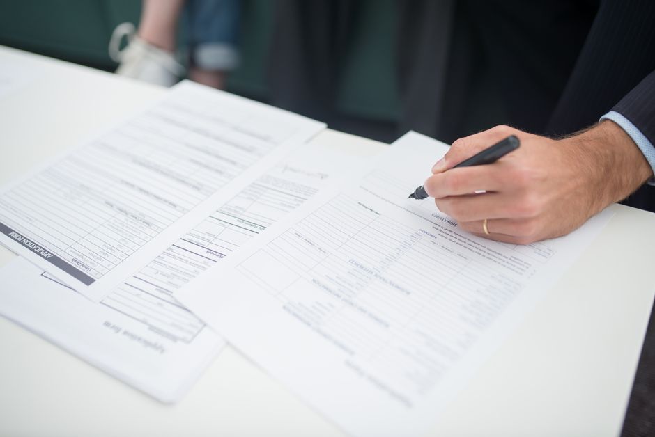 No medical exam life insurance application close-up of a hand signing the policy paperwork, the fast no medical exam life insurance approval step that replaces the old paramedical visit